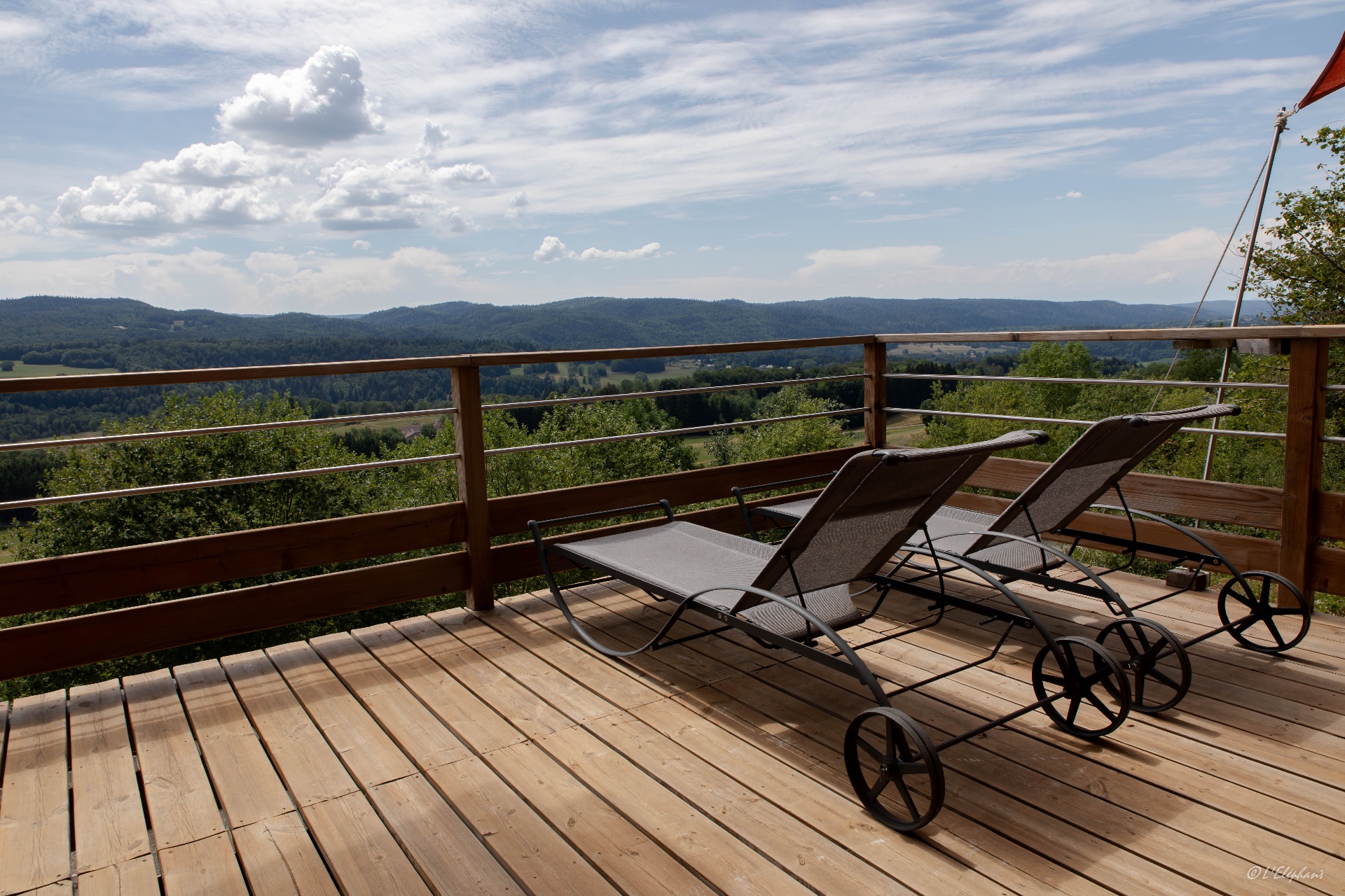 Terrasse avec transats et vue panoramique sur le Haut-Jura